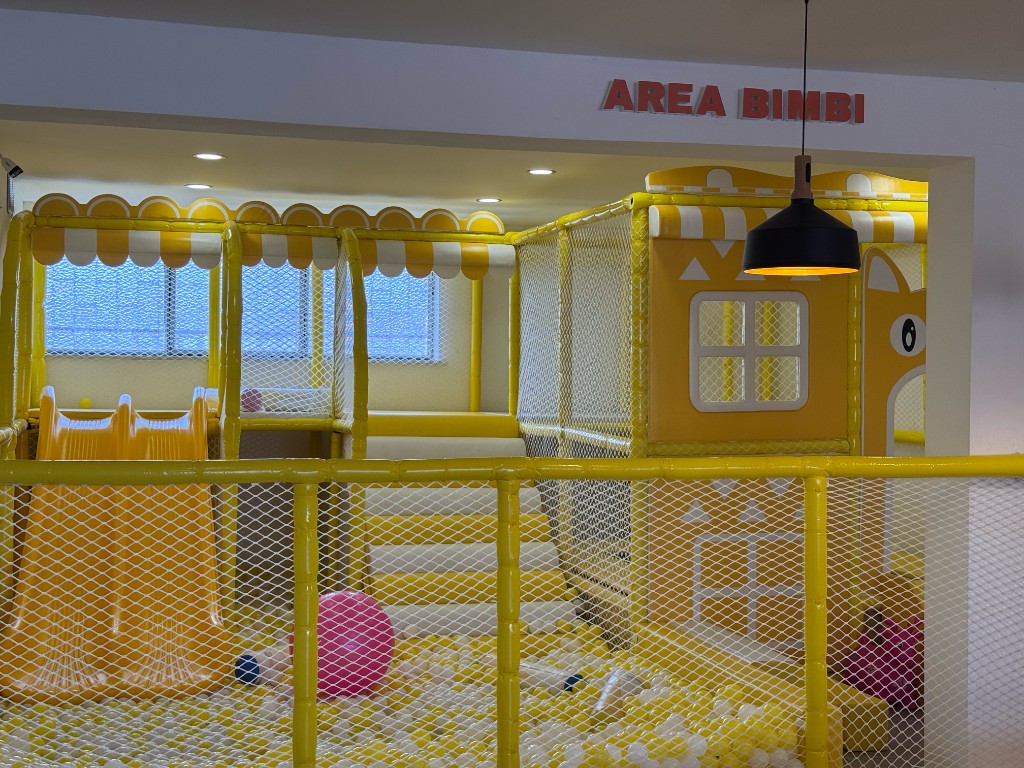 Area Bimbi LIHAY: spazio gioco recintato con scivolo, palline colorate e insegna dedicata