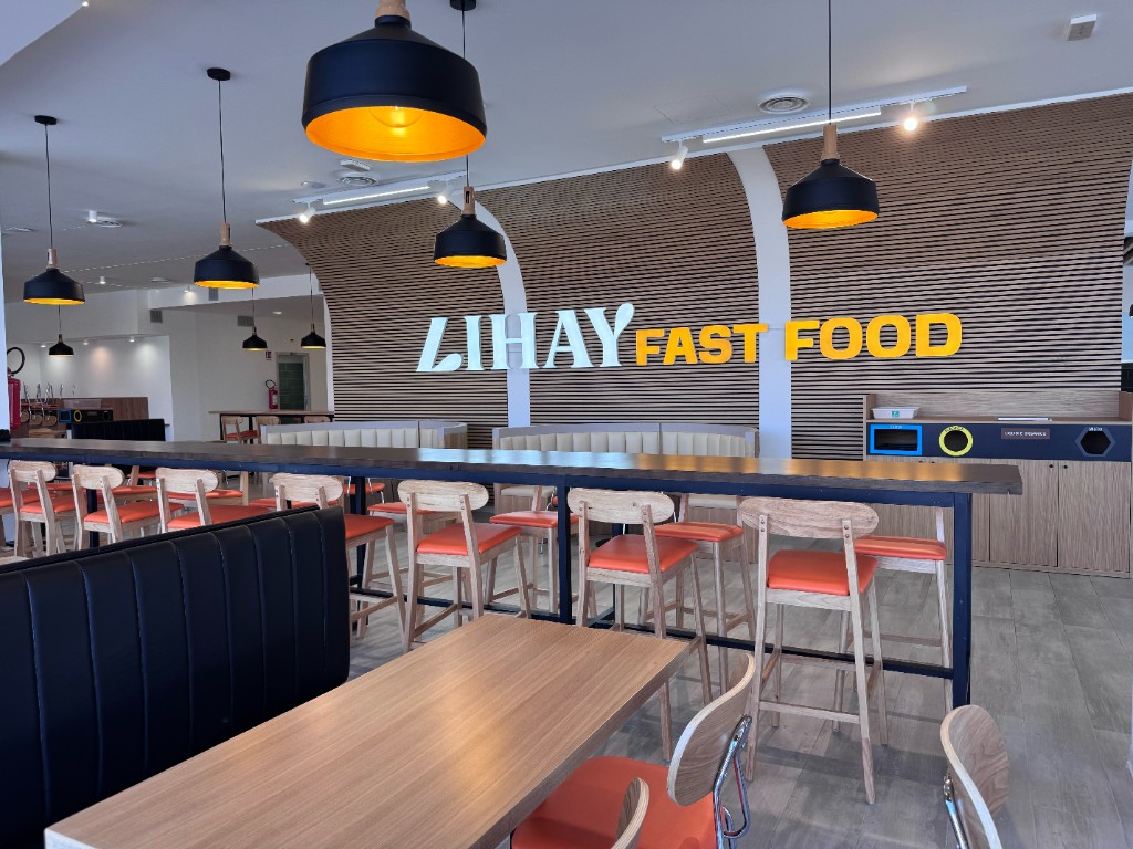 Sala LIHAY FAST FOOD: ambiente luminoso con logo sulla parete boiserie e sedute